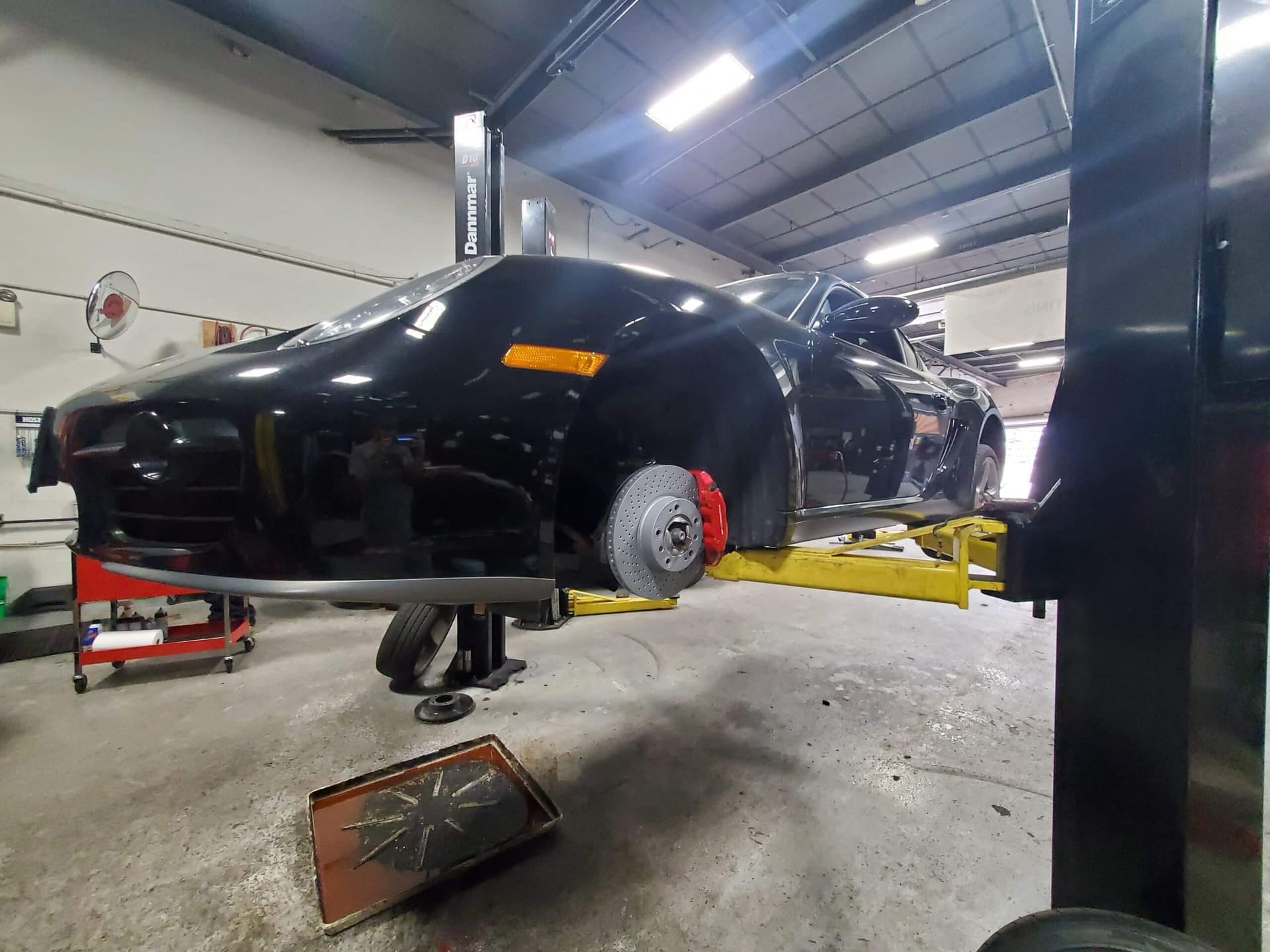 Black car elevated on a lift, prepared for brake pads replacement