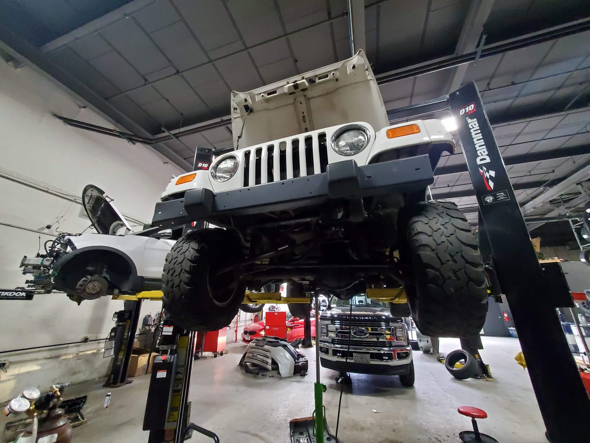 Off-road vehicle hoisted, set for brake pads replacement in a workshop