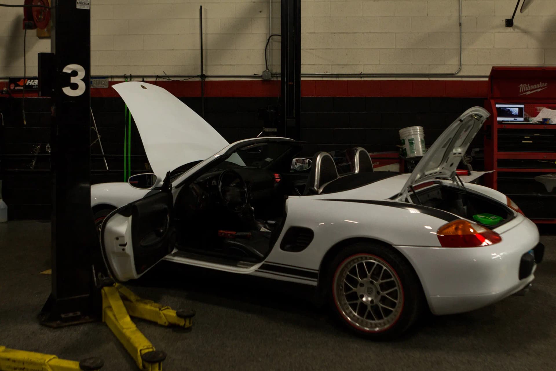 White car about to undergo brake fluid flush in a garage